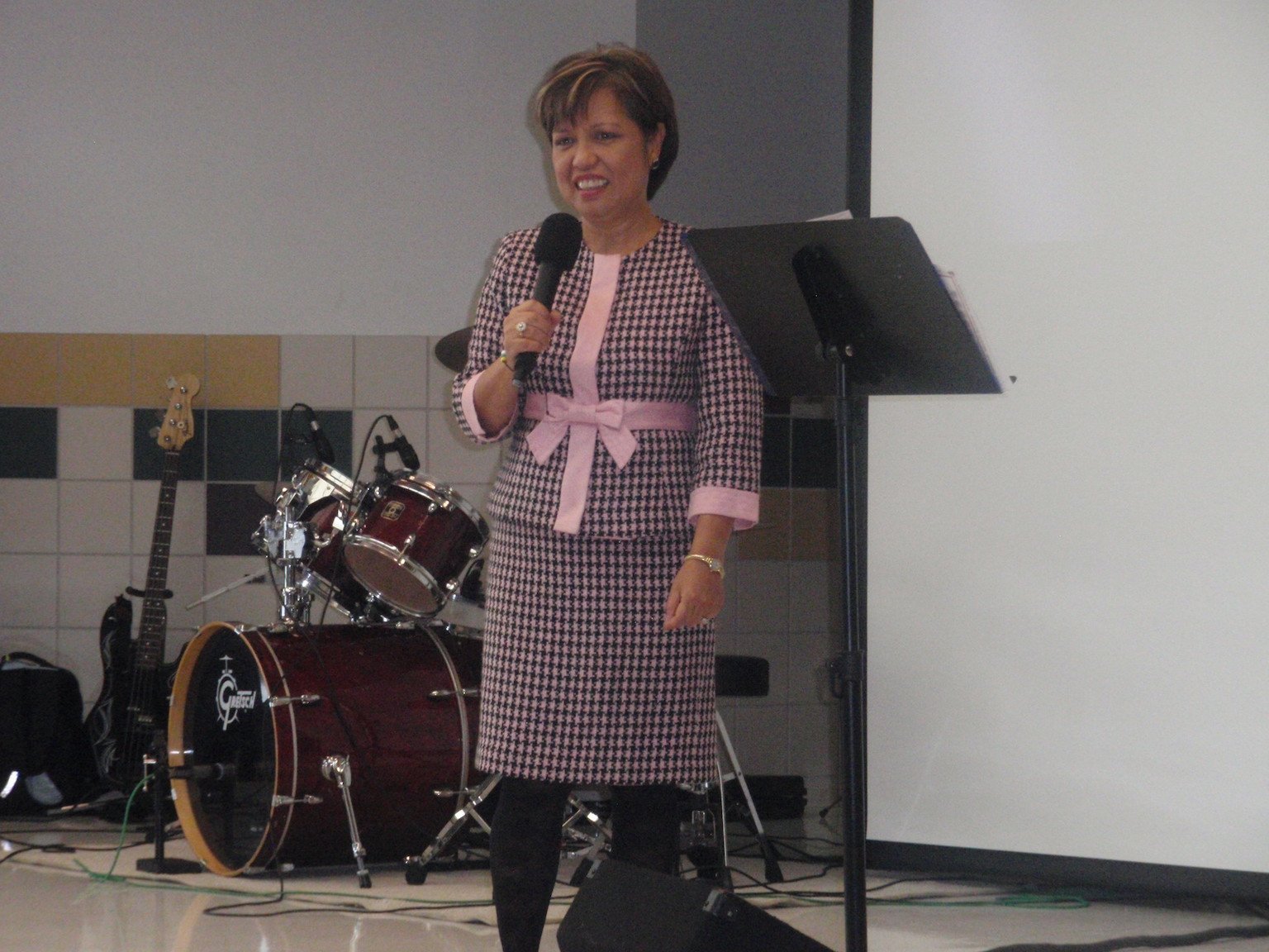 Speaking black white check dress pink bow at Dallas school